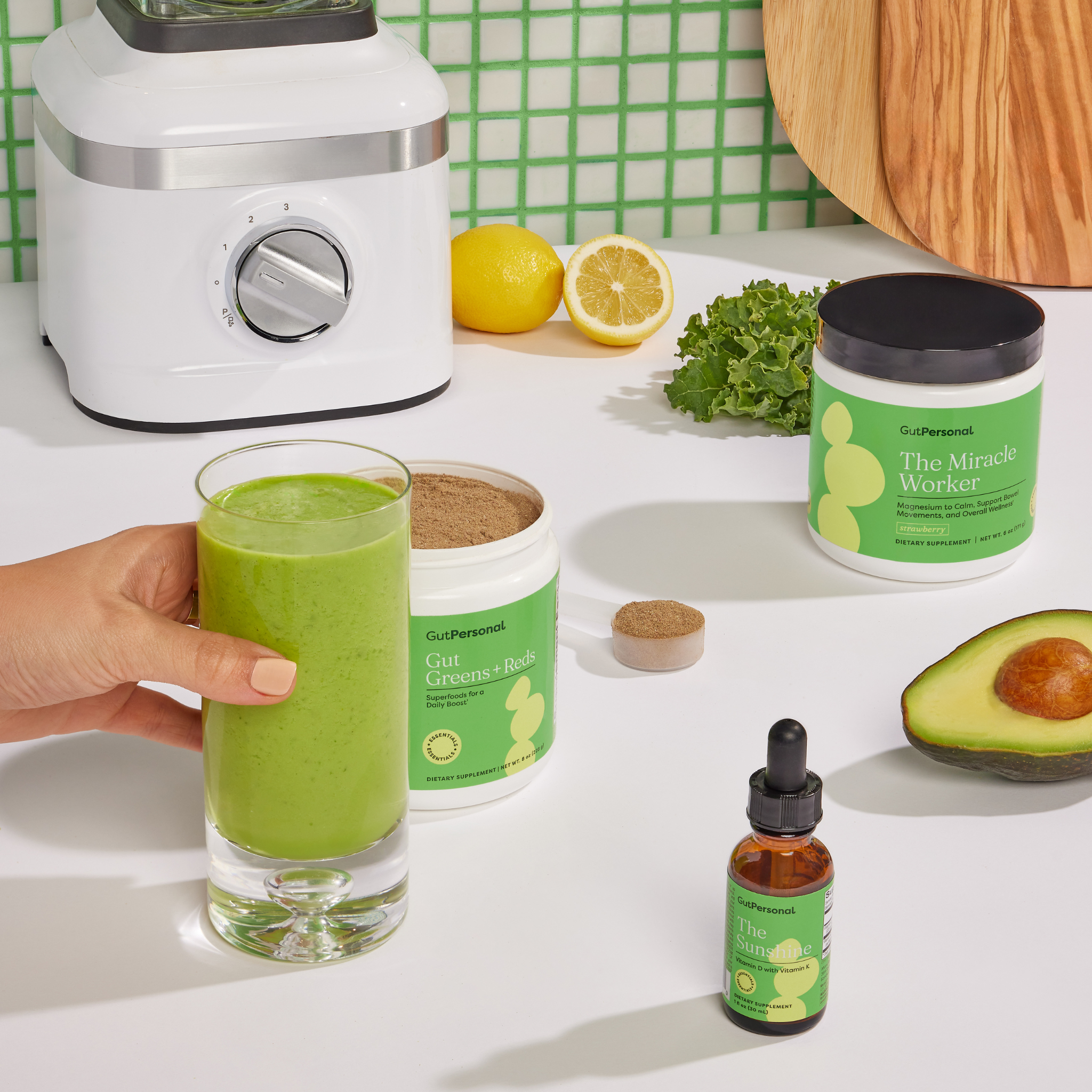 woman holding a smoothie with avocado, lemons and supplements by gutpersonal on the table