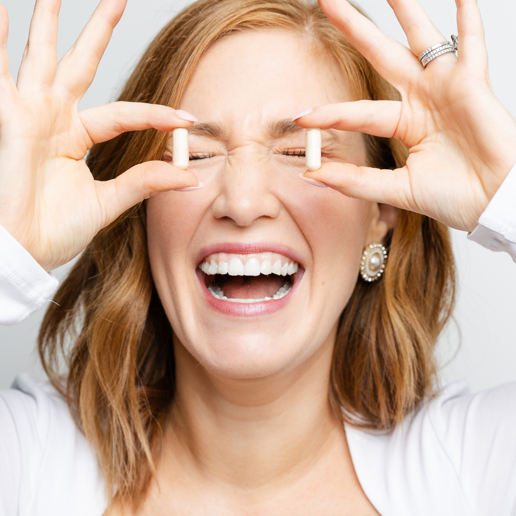 women holding supplements in front of face